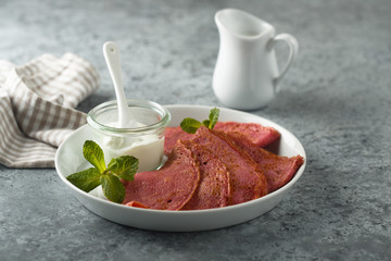 Homemade beetroot crepes with cream