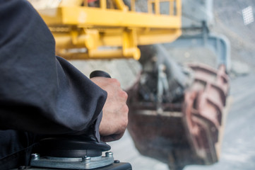 The operator’s arm controls the joystick to control the excavator bucket. The driver controls the excavator. View from the excavator cab © Yevhen