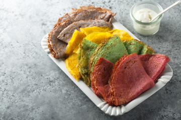 Homemade rainbow pancakes on a white plate