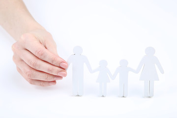 Family figures in female hand on white background