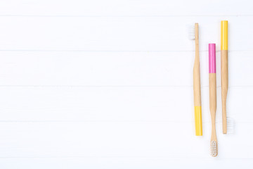 Bamboo toothbrushes on white wooden table