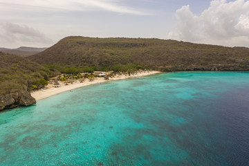 Fototapeta na wymiar Aerial view of coast of Curaçao in the Caribbean Sea with turquoise water, cliff, beach and beautiful coral reef around Playa Largu
