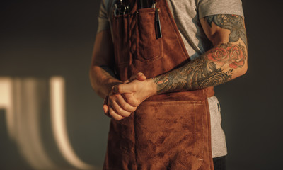 Crop barber clasping hands