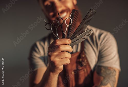Crop man showing barber tools