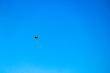lone golden balloon in the sky