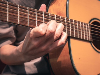Fototapeta na wymiar Close up hand on the strings of a lefty guitar