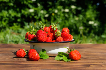 Fresh ripe strawberry on a wooden table outdoor