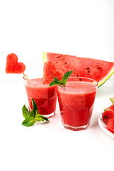 Watermelon smoothie fresh juice with mint, pieces of watermelon in the shape of hearts and slices of watermelon. Healthy drinks in glasses on a white background.