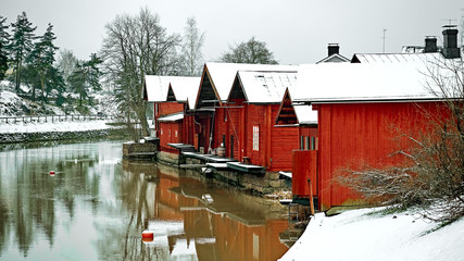 Old historic Porvoo, Finland. Red coloured vintage wooden barns storage houses on the riverside with snow in winter - 287441980