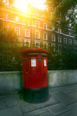 Traditional red royal post box in London UK in the morning sun light. Movie poster concept. Toned - 287442302