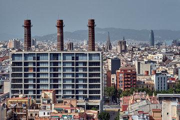 Industrial Barcelona. Three red brick chimney pipes with historic Barcelona on background - 287442355
