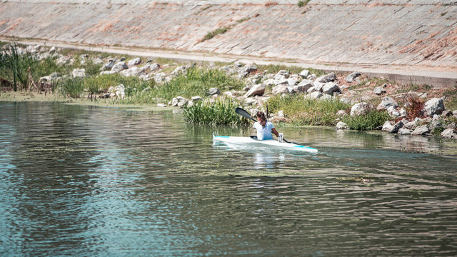 Girl kayaking on the lake, she is competing in rowing