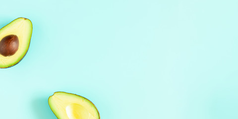 Avocado minimal pattern. Border made of green avocado on light blue background. Flat lay, top view, copy space, banner