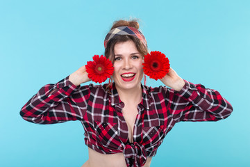 Close-up portrait of a beautiful young woman holding red flowers with different hearts in the hands...