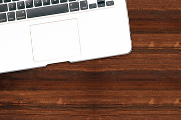 Modern aluminum computer keyboard isolated on wooden background