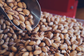 Pistachios nuts on pistachios background. Healthy snacks. Close up image. Free space for text.