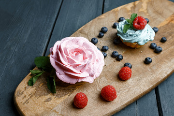 Muffin with cream and berries on tablet