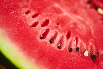 Fresh ripe striped sliced watermelon on wooden table with blurred garden sunset background. Food, Fruits or healthcare concept.