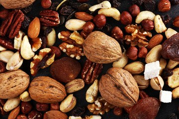 Composition with dried fruits and assorted healthy nuts on rustic background