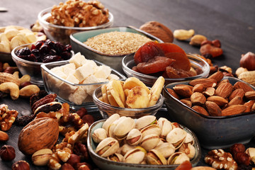 Composition with dried fruits and assorted healthy nuts on rustic background