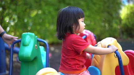 A cute young Asian Child baby girl kid age 2 plays in playground ,Concept photo childhood 