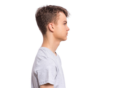 Side view of portrait of teen boy in blank gray t-shirt, isolated on white background. Happy child - profile. Schoolboy looking away.