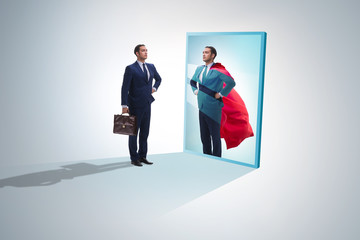 Businessman seeing himself in mirror as superhero