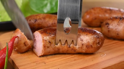 Knife cuts traditional Brazilian barbecue sausage close	