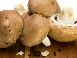 Close-up of raw and untreated champignons on a wooden plate