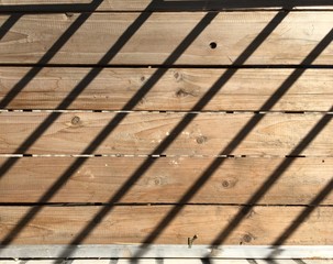 a top-down shot of the plywood with cast shadows from steel bars