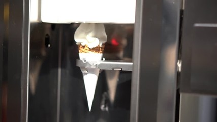 Human hand holding cone with twisted ice cream from machine 