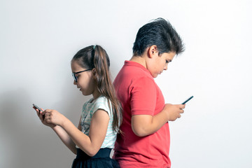 A little girl and a boy looking at smartphones. Children are passionate about social networks
