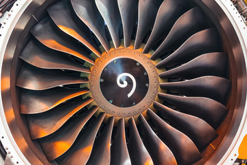 Close up of a turbofan turbine blades jet engine in modern airplane warm shade light.