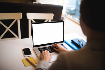 Closely contemporary laptop computer with white mock up empty screen with copy space for advertising content. Business woman keyboarding on portable netbook, sitting in coffee shop. Training course