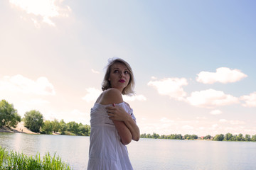 Fototapeta premium Portrait of a young girl in a dress near the lake.