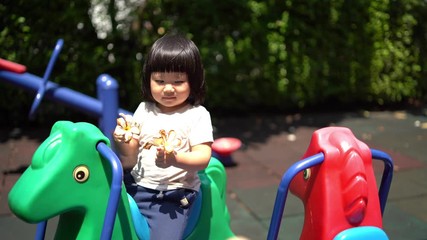 A cute young Asian Child baby girl kid age 2 plays in playground ,Concept photo childhood 