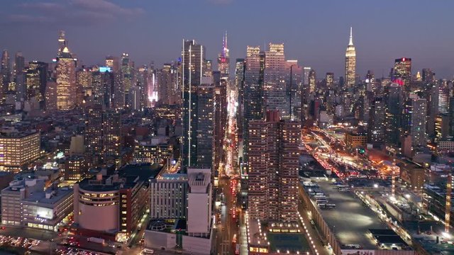 Aerial drone footage of New York skyline along 42nd street canyon, at dusk, with pull back camera motion
