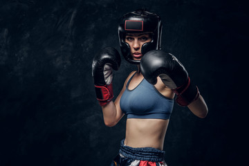 Portrait of attractive boxer in protective helmet and gloves ready to fight.