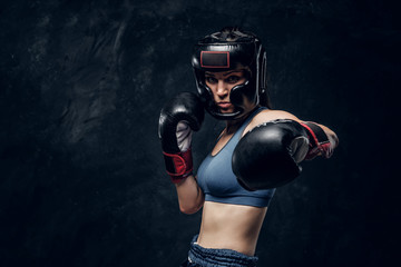 Fototapeta na wymiar Portrait of attractive boxer in protective helmet and gloves ready to fight.