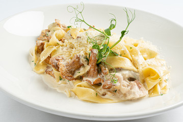 pasta with chanterelles on white plate