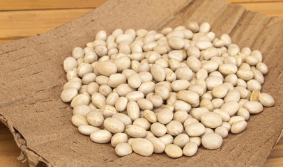Some white beans on a wooden background