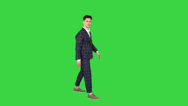 Businessman makes a back flip and shows cool gesture to camera after on a Green Screen, Chroma Key.