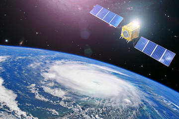 Monitoring hurricane. Satellite above the Earth makes measurements of the weather parameters and...