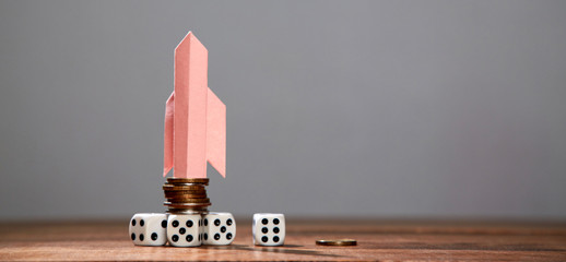 Begininning, finance, investment, saving and growth concept. Paper rocket, stack of coins and dice