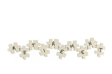 jigsaw puzzle pieces with letters written on them spelling out retirement isolated on white for the concept of the difficulty of planning and funding retirement