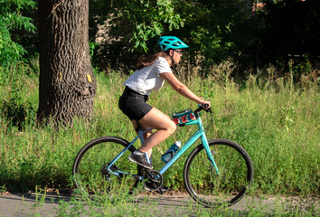 Fototapeta premium young beautiful woman riding a bicycle in a park. Active people. Outdoors