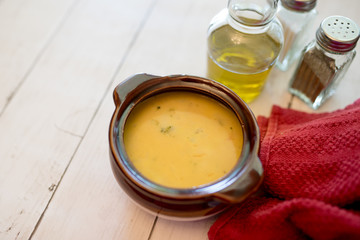 broccoli cheese soup served in a brown bowl 