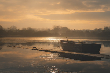 Sailing boats on a lake during a frosty winter sunrise