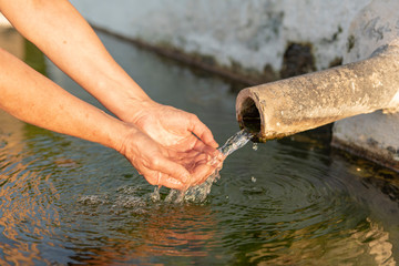 Se lava las manos en el agua de la fuente