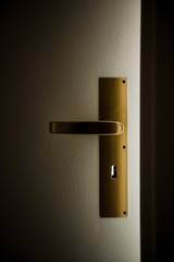 Cinematic opened door with light passing through keyhole - hope, future, dreams, security concept